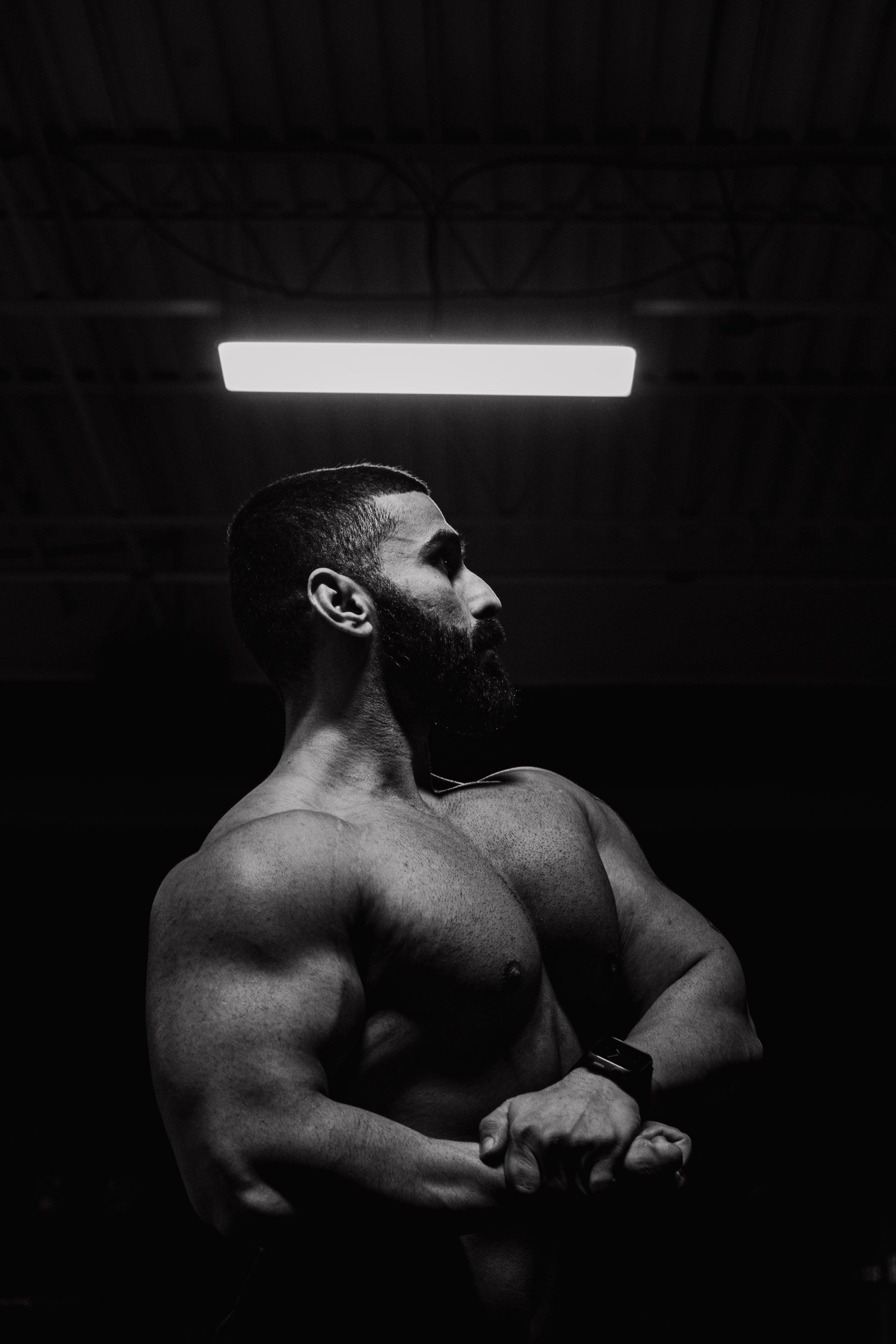 Strong side profile showcasing chest and shoulders with dramatic cinematic lighting