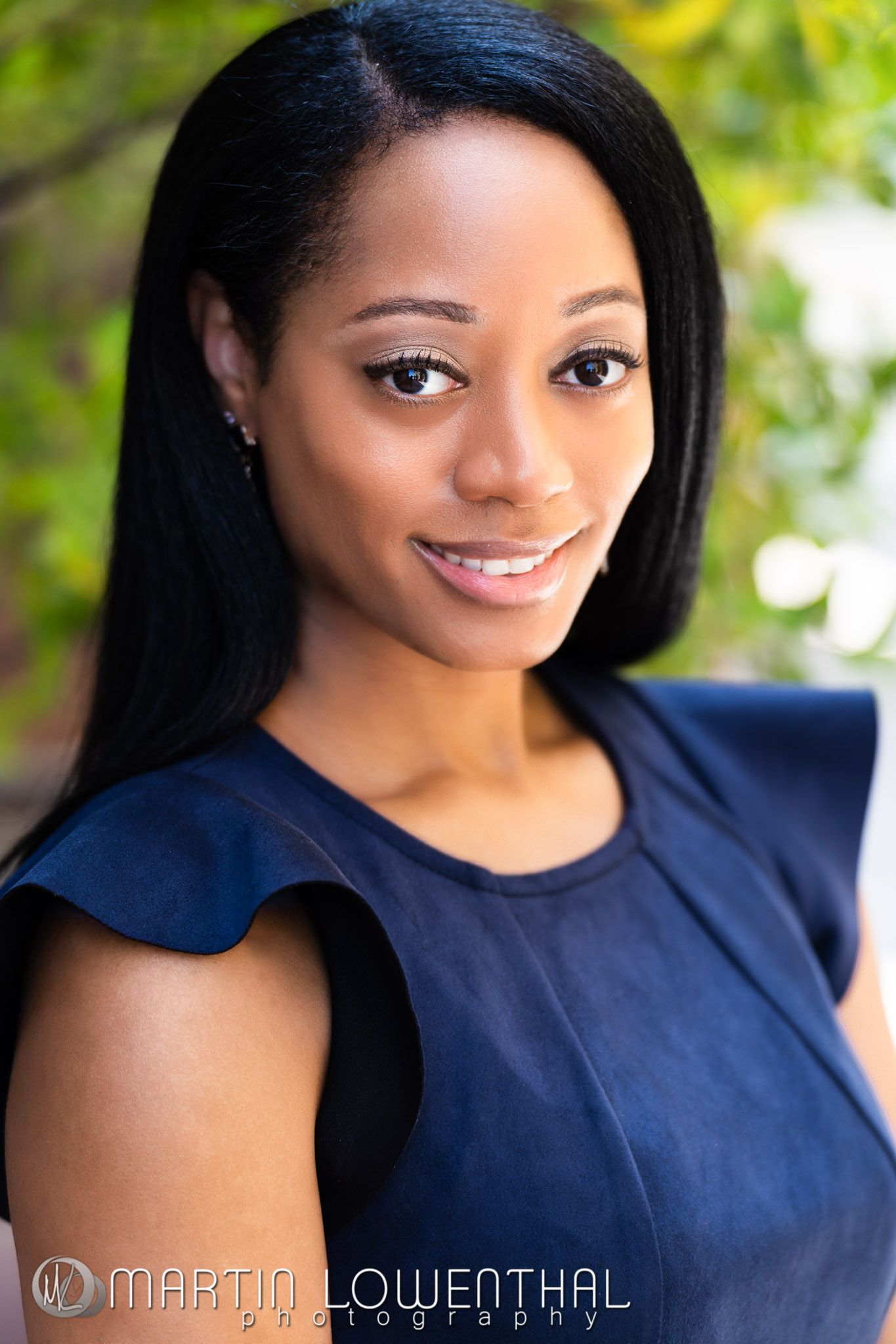 Professional portrait series in navy blue attire against natural outdoor background.