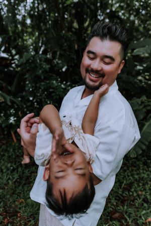 A heartwarming moment of family play and laughter in a garden setting.