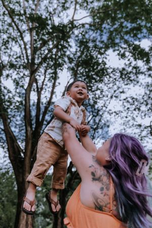 Joyful outdoor playtime beneath tall trees on a summer day.