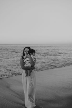Black and white photo of loving embraces on a serene beach landscape.
