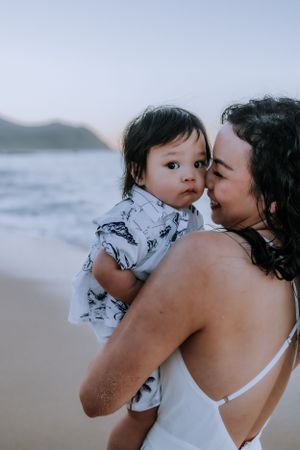 Tender moments shared between parent and child on a peaceful beach.