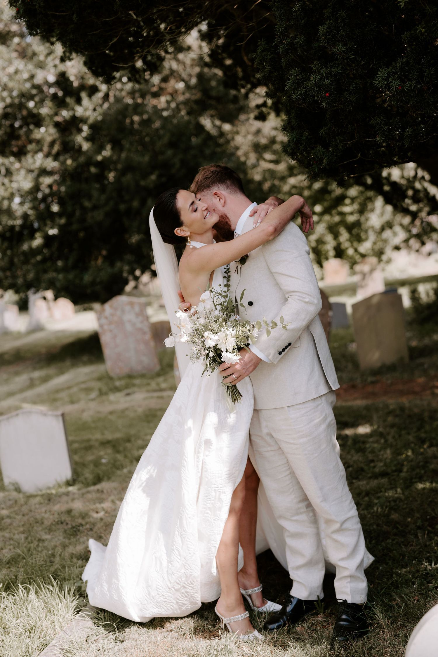 bride and groom hugging outside st Nicholas church in Oxfordshire