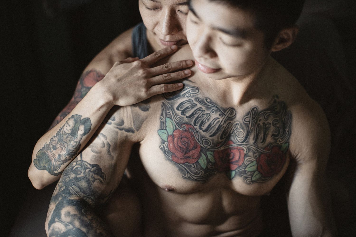 couple with tattoos leaning on each other