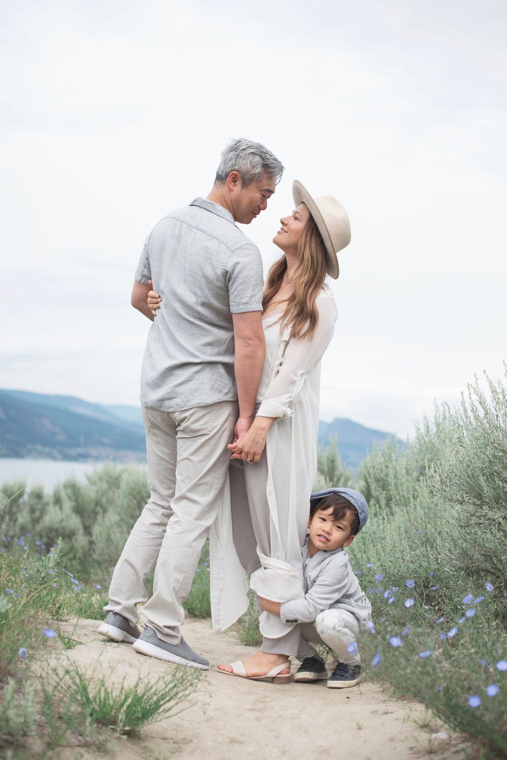 Intimate family portrait on a mountain trail with wildflowers and lake views at Penticton, B.C.