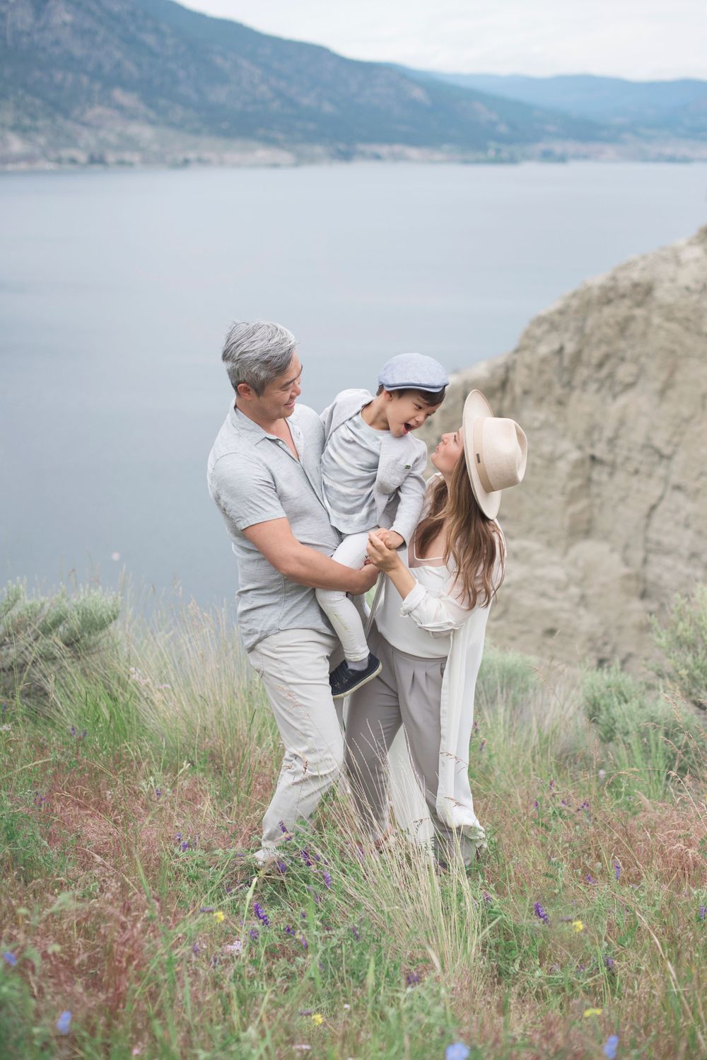 Family enjoying playful moments together a scenic mountain overlook above Okanagan Lake at Penticton, B.C.