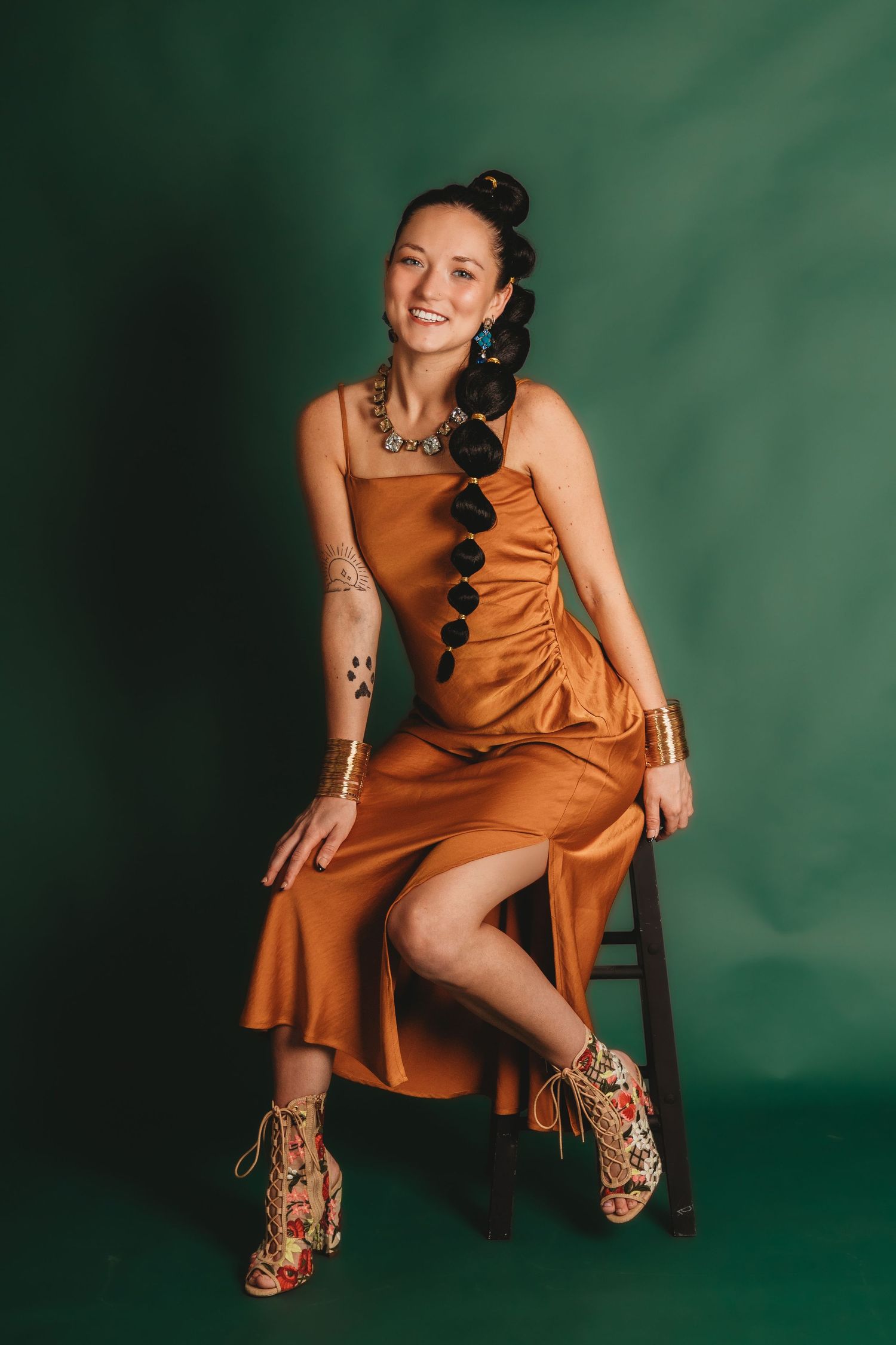 Fashion portrait series in rust-colored dress against deep green background.