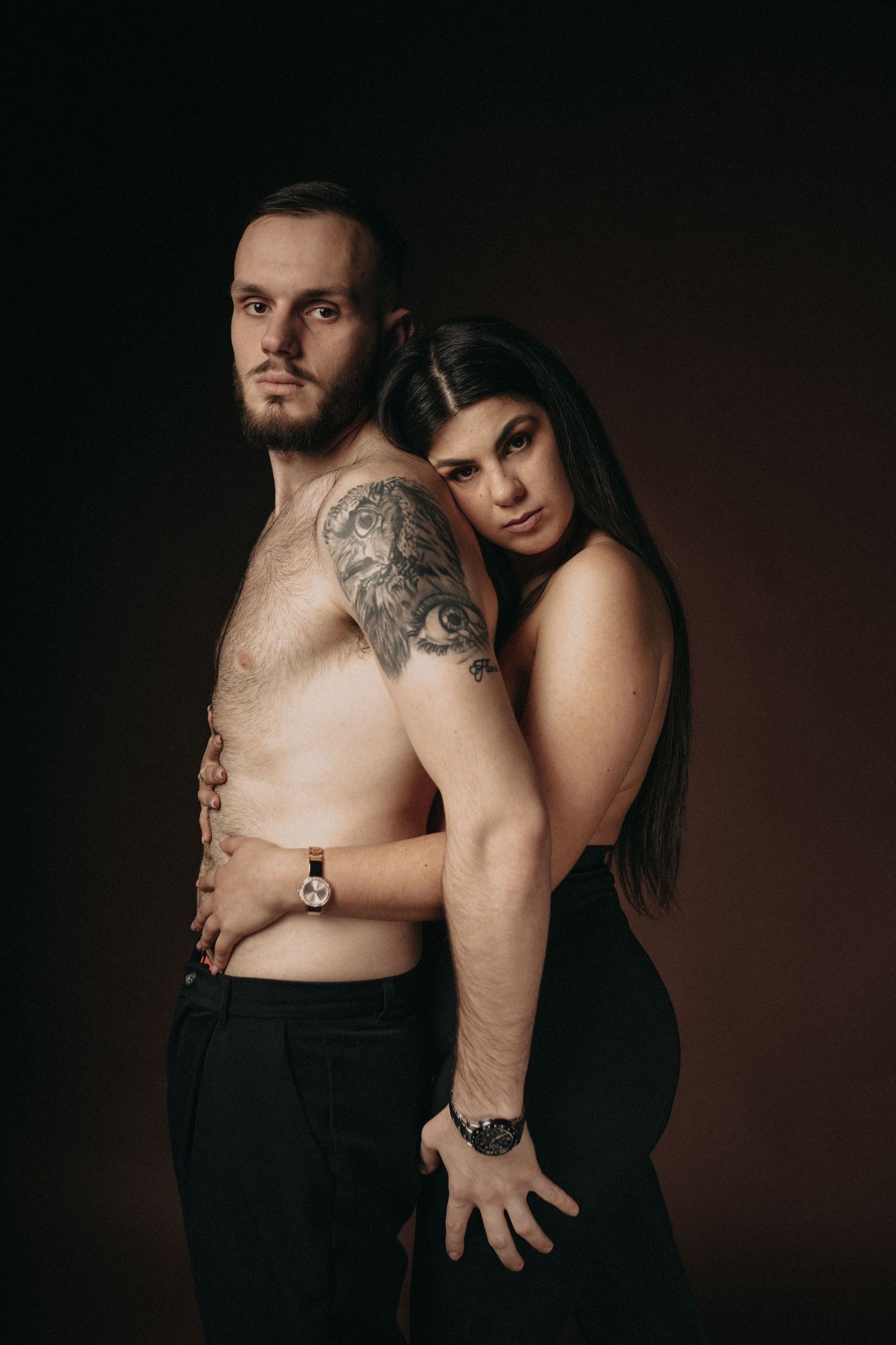 Intimate couples boudoir photography session against dark background showing emotional connection.