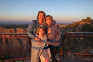 Visitors gathered at scenic overlook enjoying sunset views of canyon landscape.