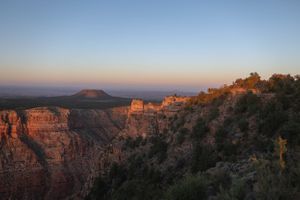Sweeping vista of red rock formations and deep canyons at the Grand Canyon during golden hour.