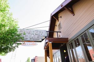 Exterior view of a rustic restaurant storefront with wooden siding.