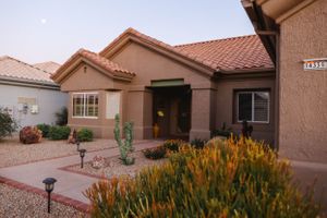 Desert-style homes with terracotta roofs and yellow wildflowers in the landscaping.