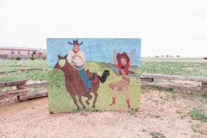 Painted western-themed mural featuring cartoon characters on an outdoor wall.