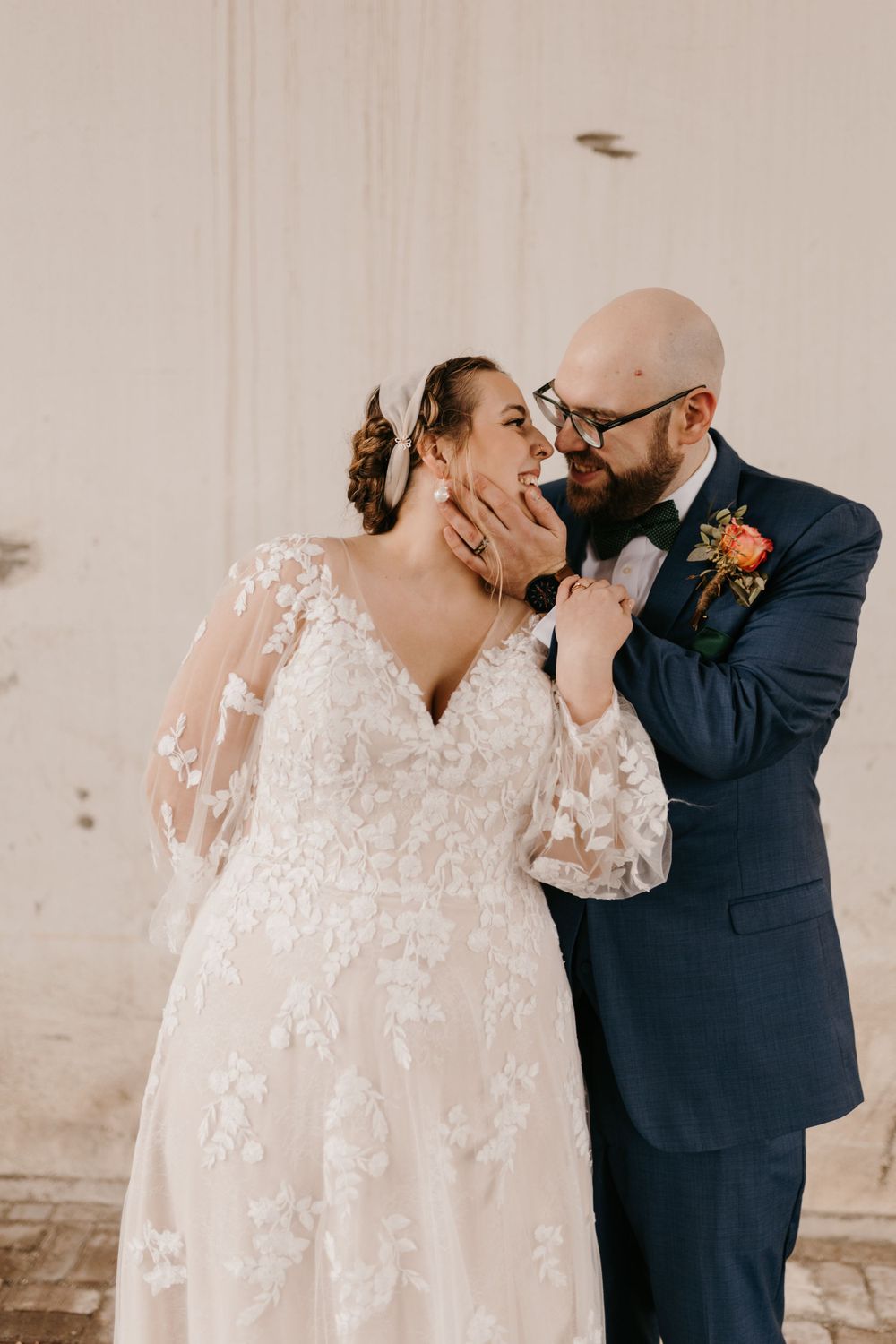 Groom tenderly holding bride's face as they share an intimate wedding moment.