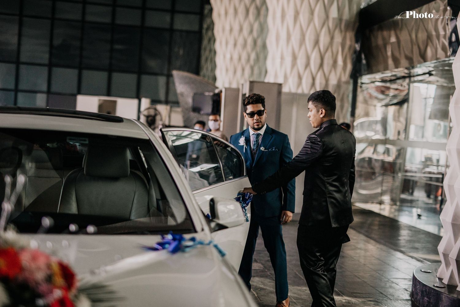 People walking through a modern parking structure with geometric patterns.