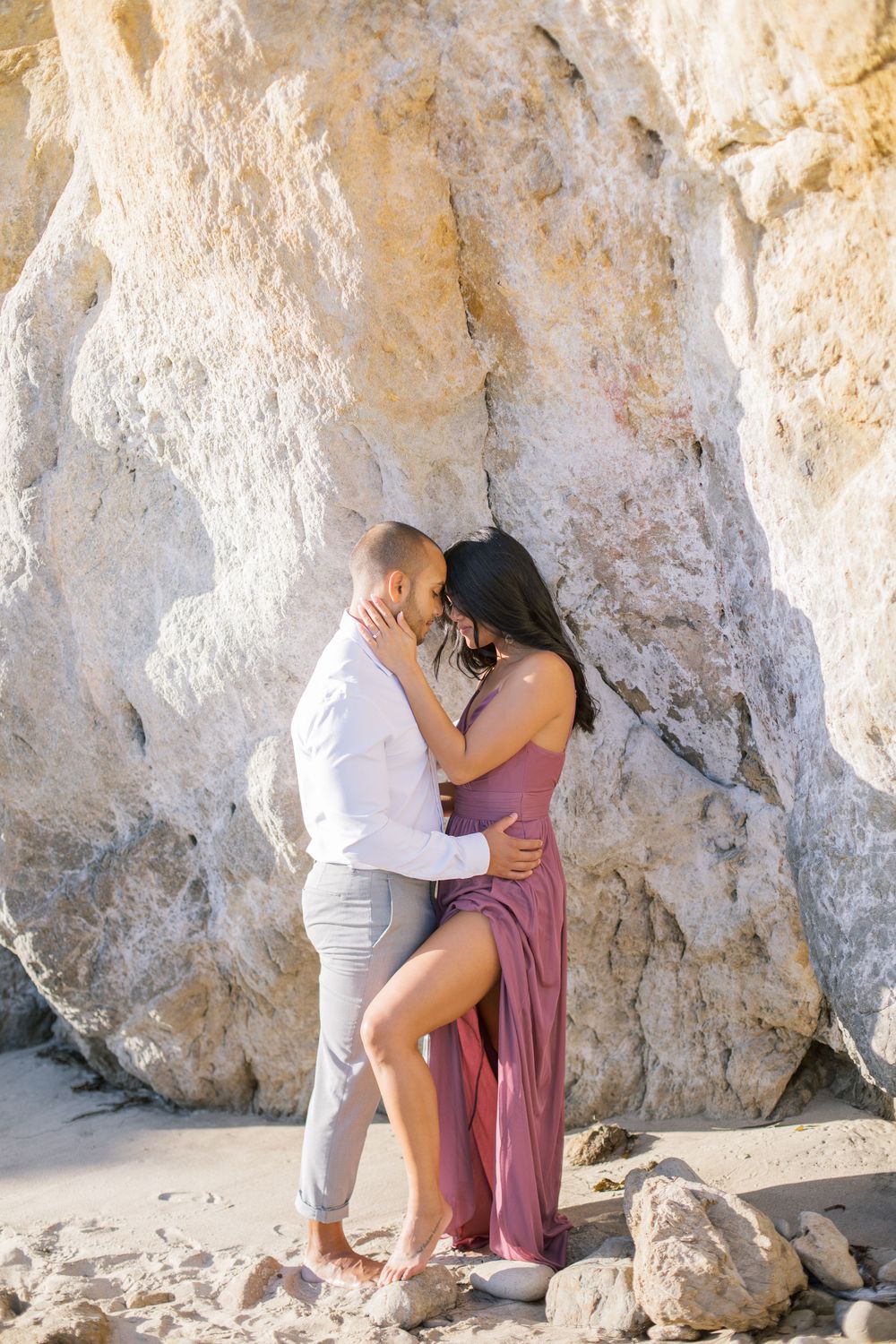 Romantic embrace in a natural rock cave formation at the beach.