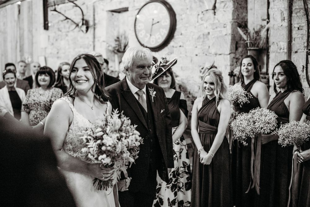 Black and white emotional wedding ceremony moment in rustic stone venue.