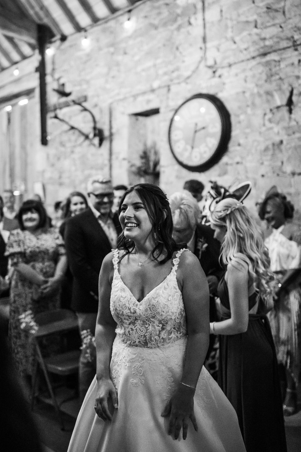 Black and white candid reception photo showing joyful celebration in rustic venue.