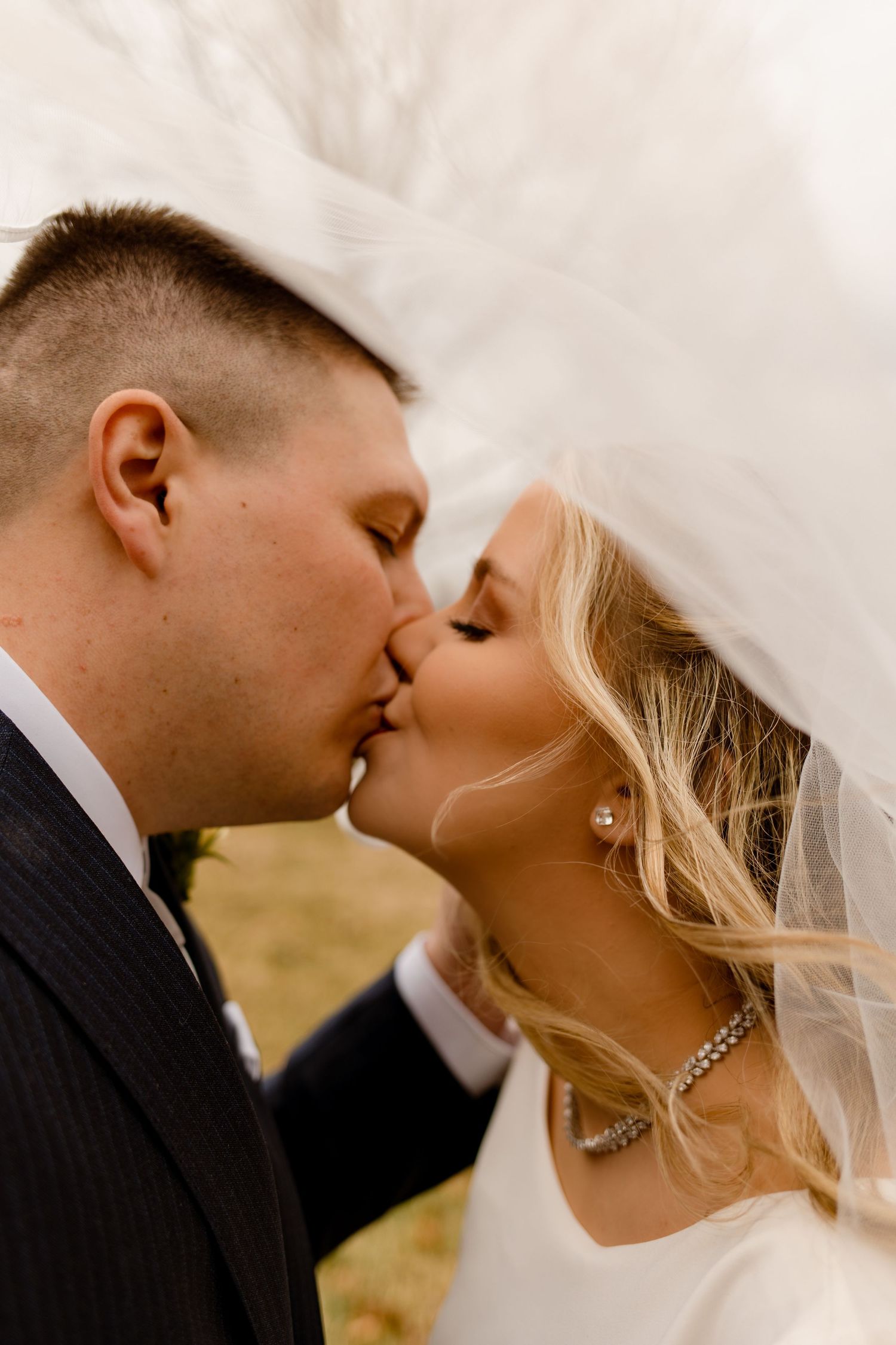 An intimate wedding portrait under a flowing white veil.