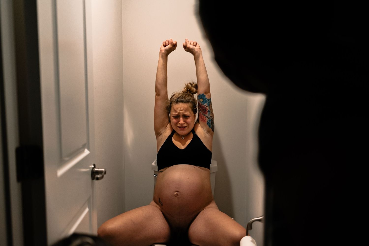 Lady Laboring On Toilet With Her Arms In The Air