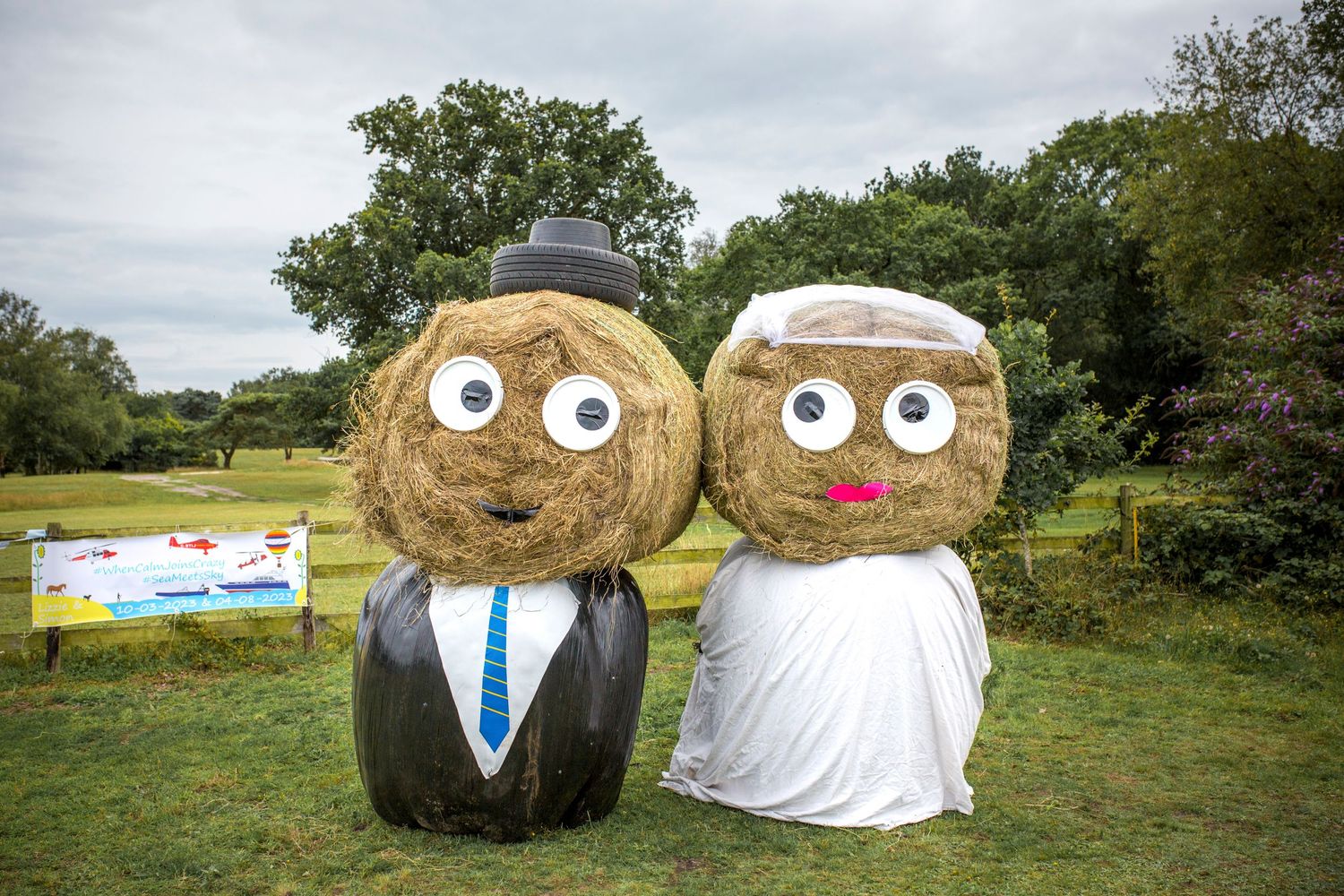 Creative hay bale wedding decorations with googly eyes displayed in a rustic outdoor field setting.