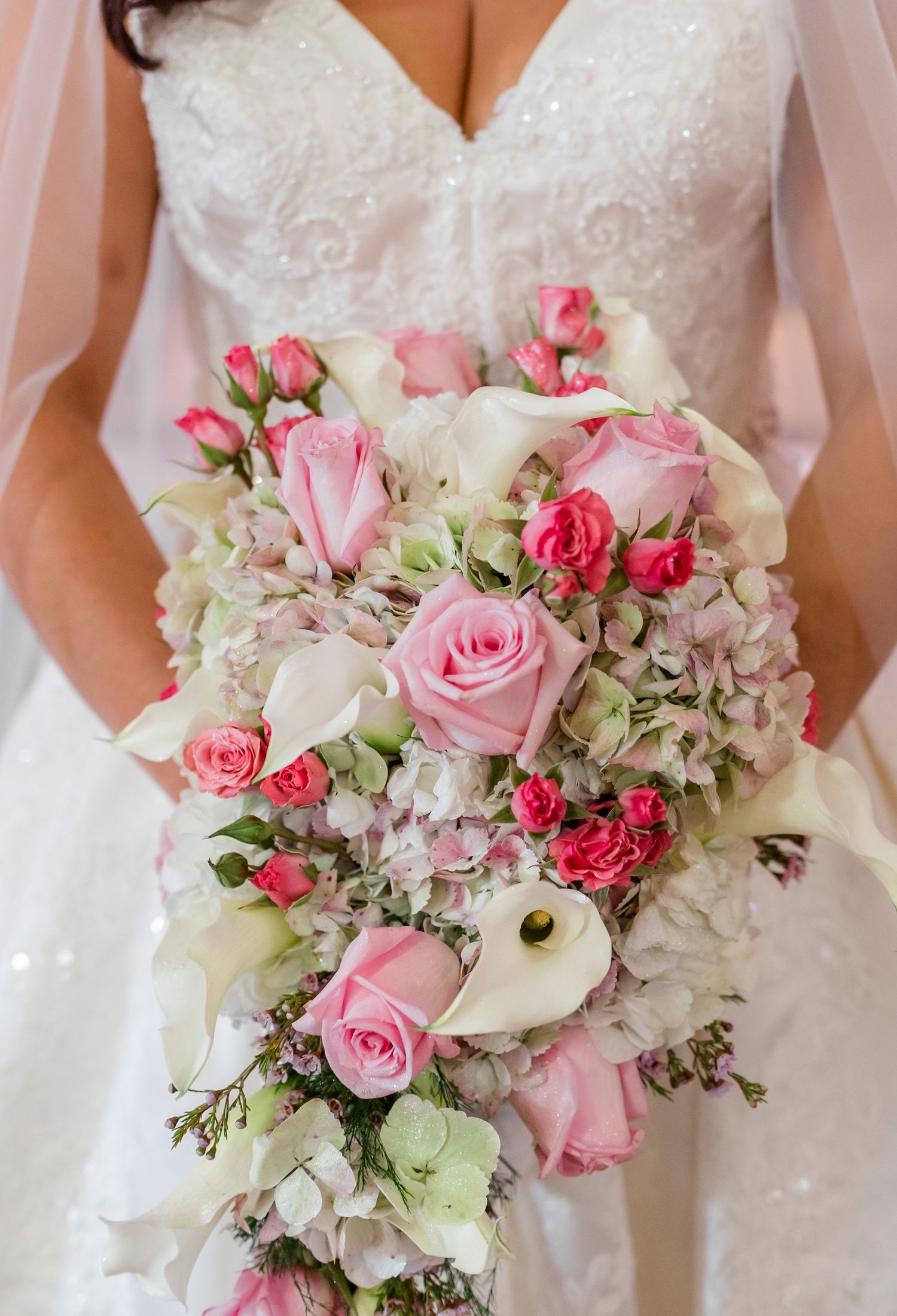 Elegant bridal bouquets featuring pink roses, white calla lilies, and hydrangeas arranged in a row.