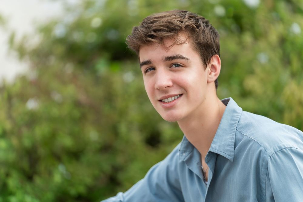 Landa Gardens at Landa Library  portrait of high school senior boy in blue shirt