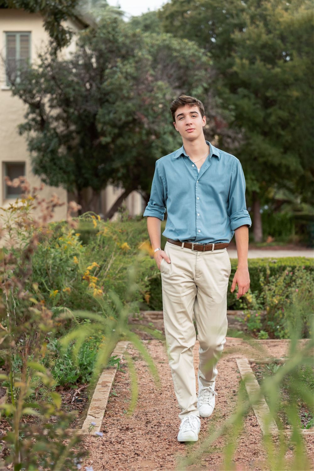 High school senior boy walking through Landa Garden at Landa Library