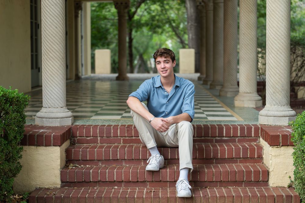 Senior high school boy sitting on the steps  of Landa Library