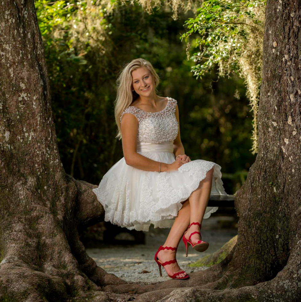 Senior portrait between the trees at Magnolia Gardens