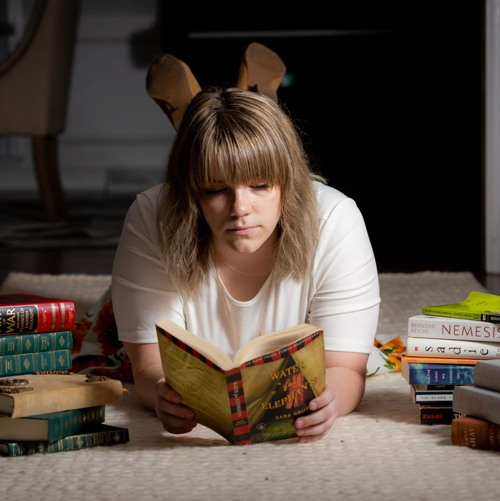 Reading surrounded by books Senior portrait