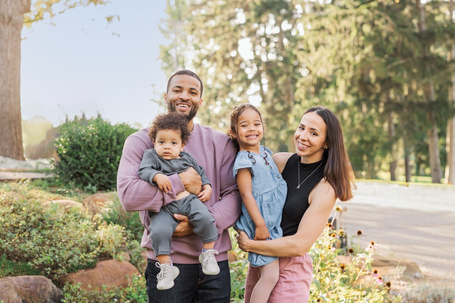 Family shares joyful moments together in a sunny outdoor garden setting.