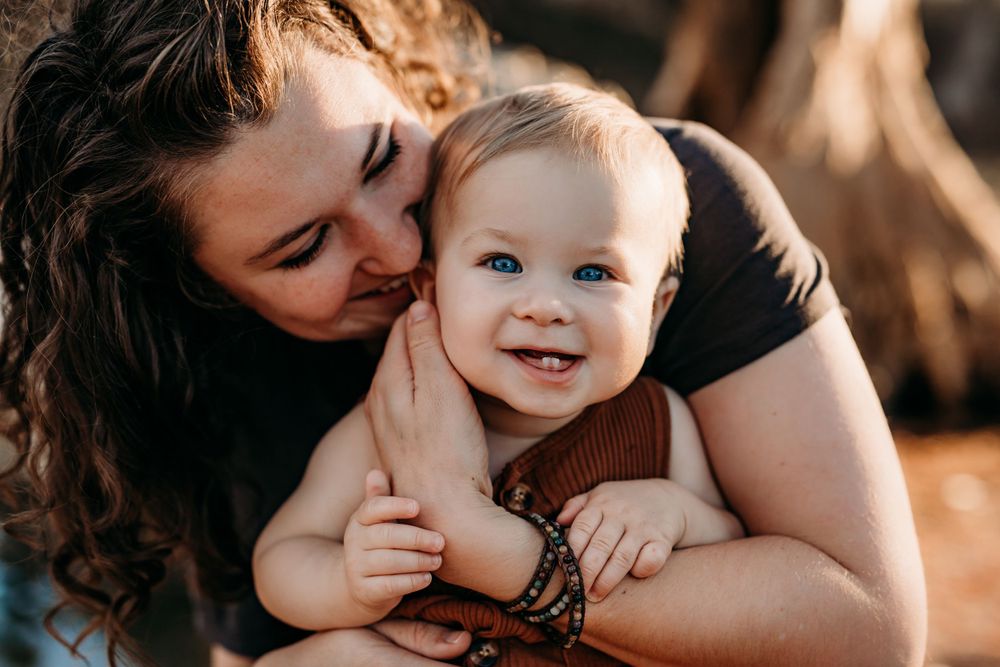 Mom kissing blue eyed baby
