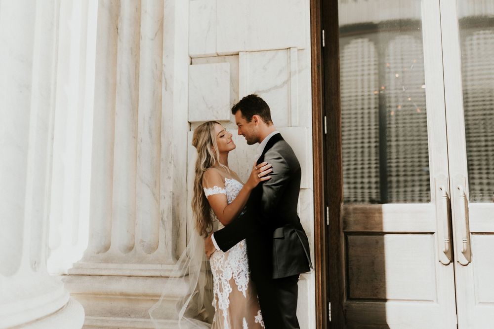 Intimate wedding portrait against classic white columns and wooden doors.
