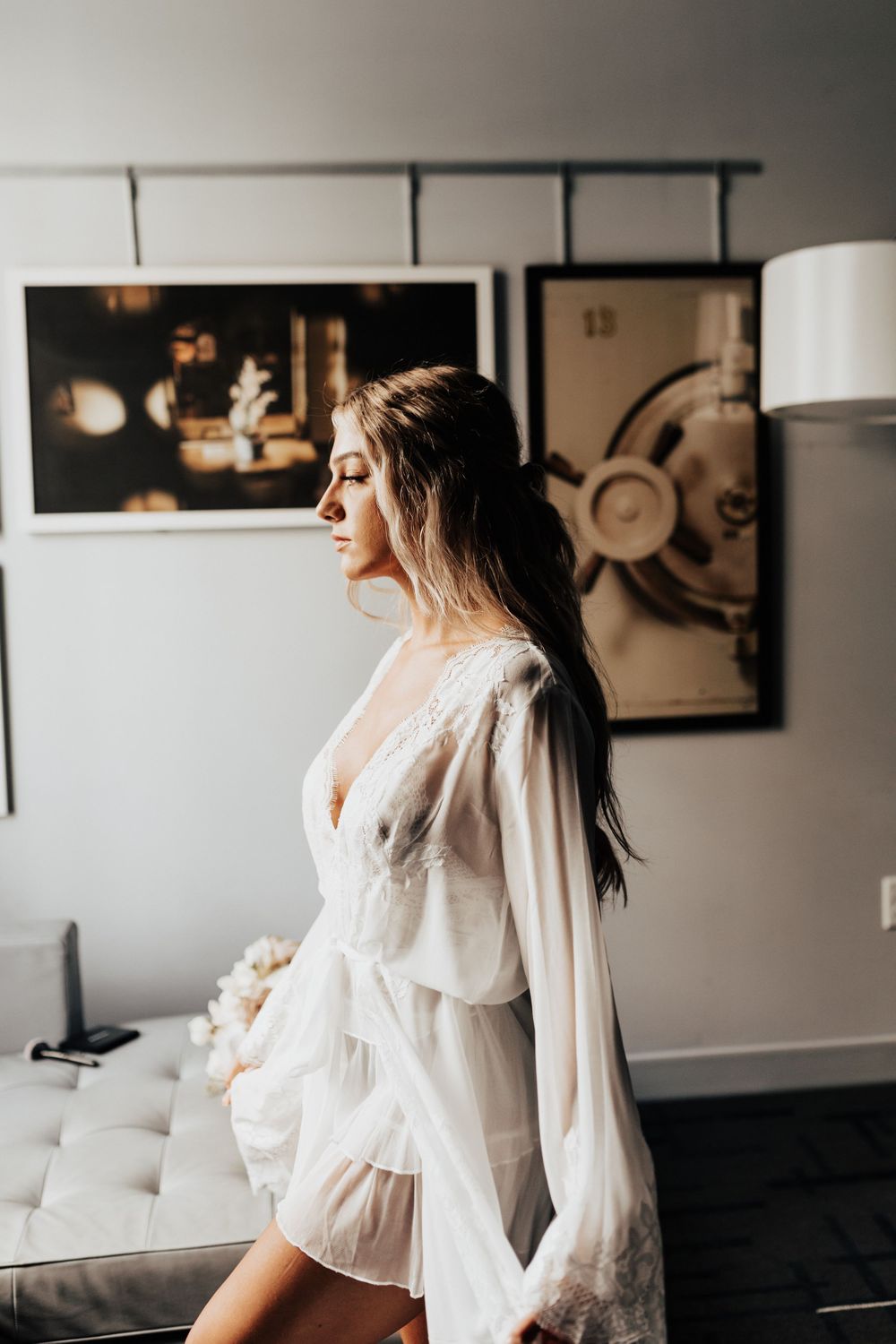 White lace robe captured in side profile against modern room with artwork.