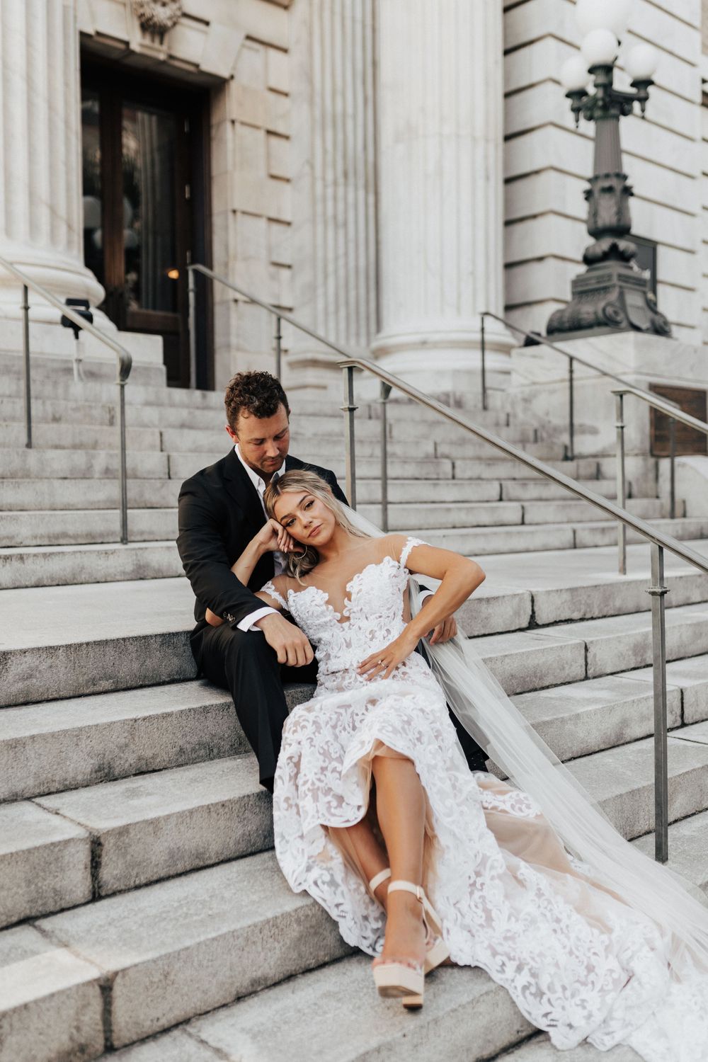 Intimate wedding moment captured on stone steps with classic architecture backdrop.