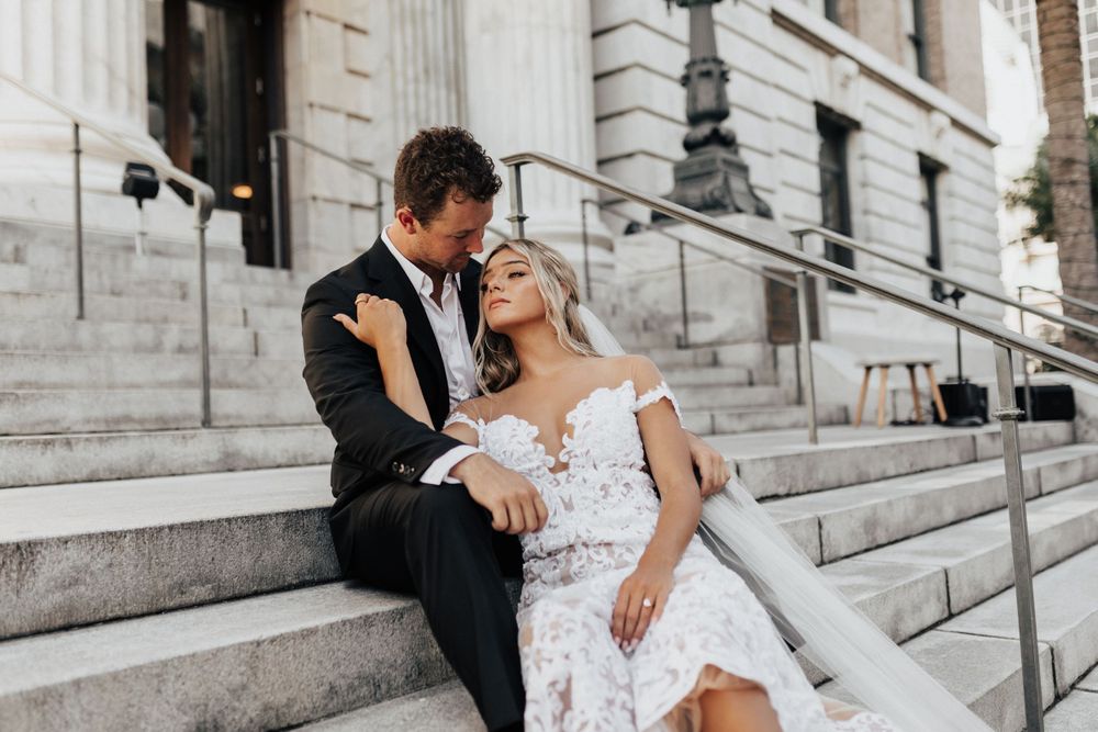 Romantic wedding portrait on stone steps with classic architectural backdrop.