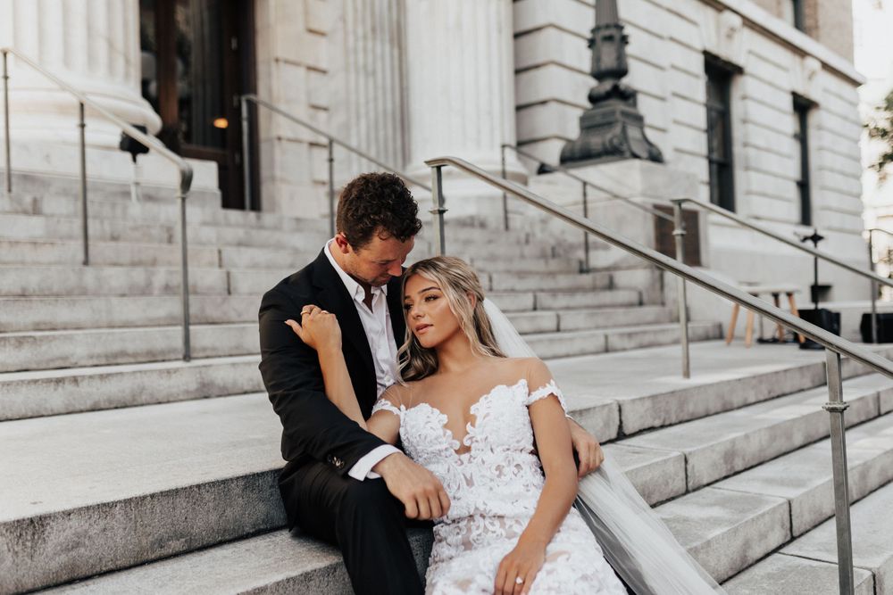 Romantic wedding portrait on historic stone steps with classical columns.