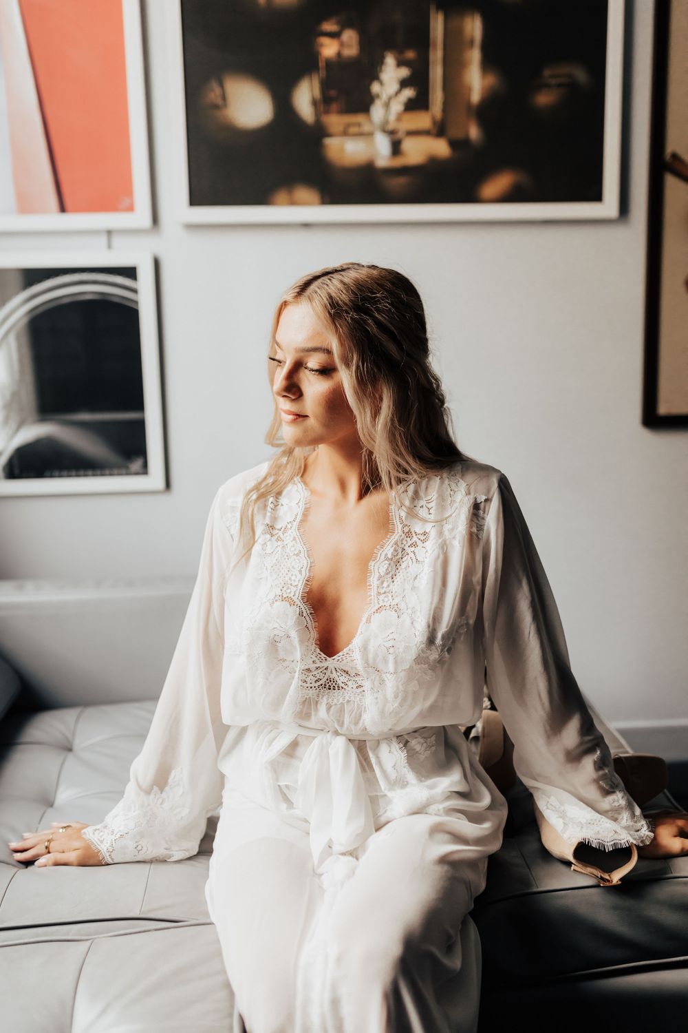 A delicate white lace robe with intricate details drapes elegantly against a modern interior setting.