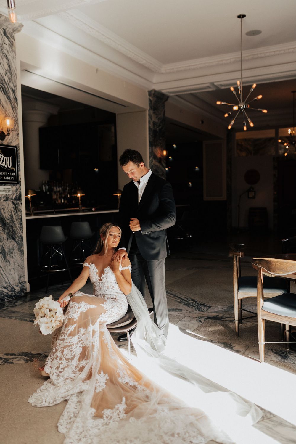 A glamorous wedding scene with modern decor featuring a stunning lace gown with flowing train.
