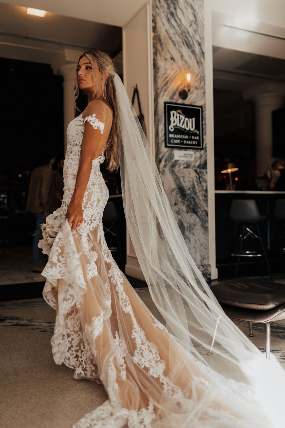 A beautiful wedding gown with intricate lace details and flowing train captured in profile.