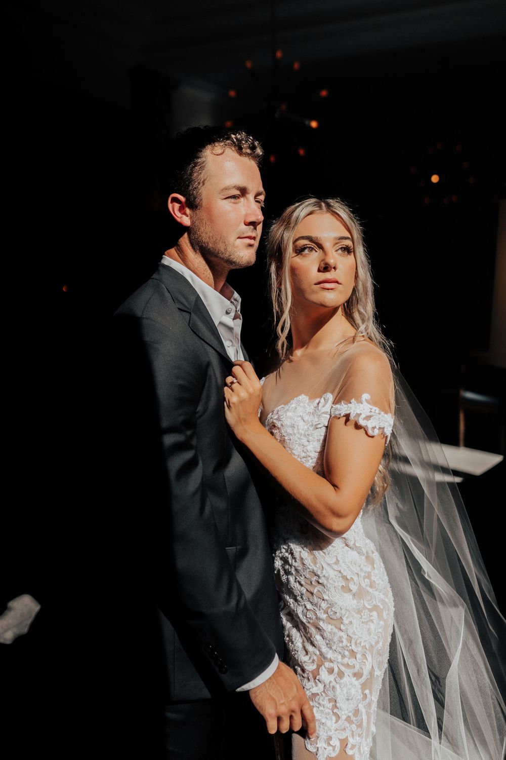 A stunning wedding portrait with dramatic lighting highlighting an intimate embrace.