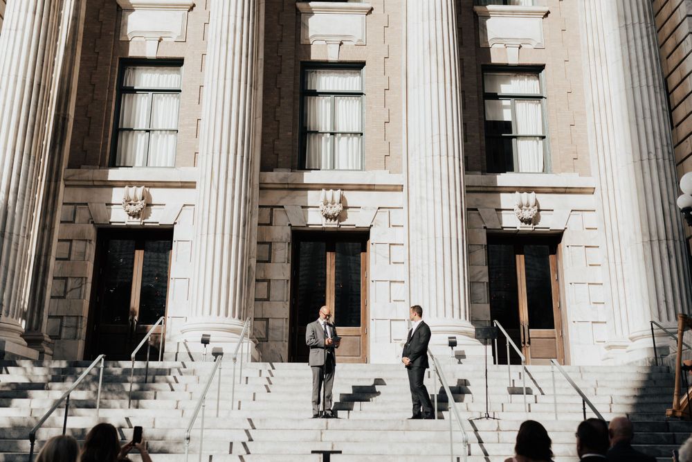 Classical building exterior with grand stone columns and steps leading to entrance doors.