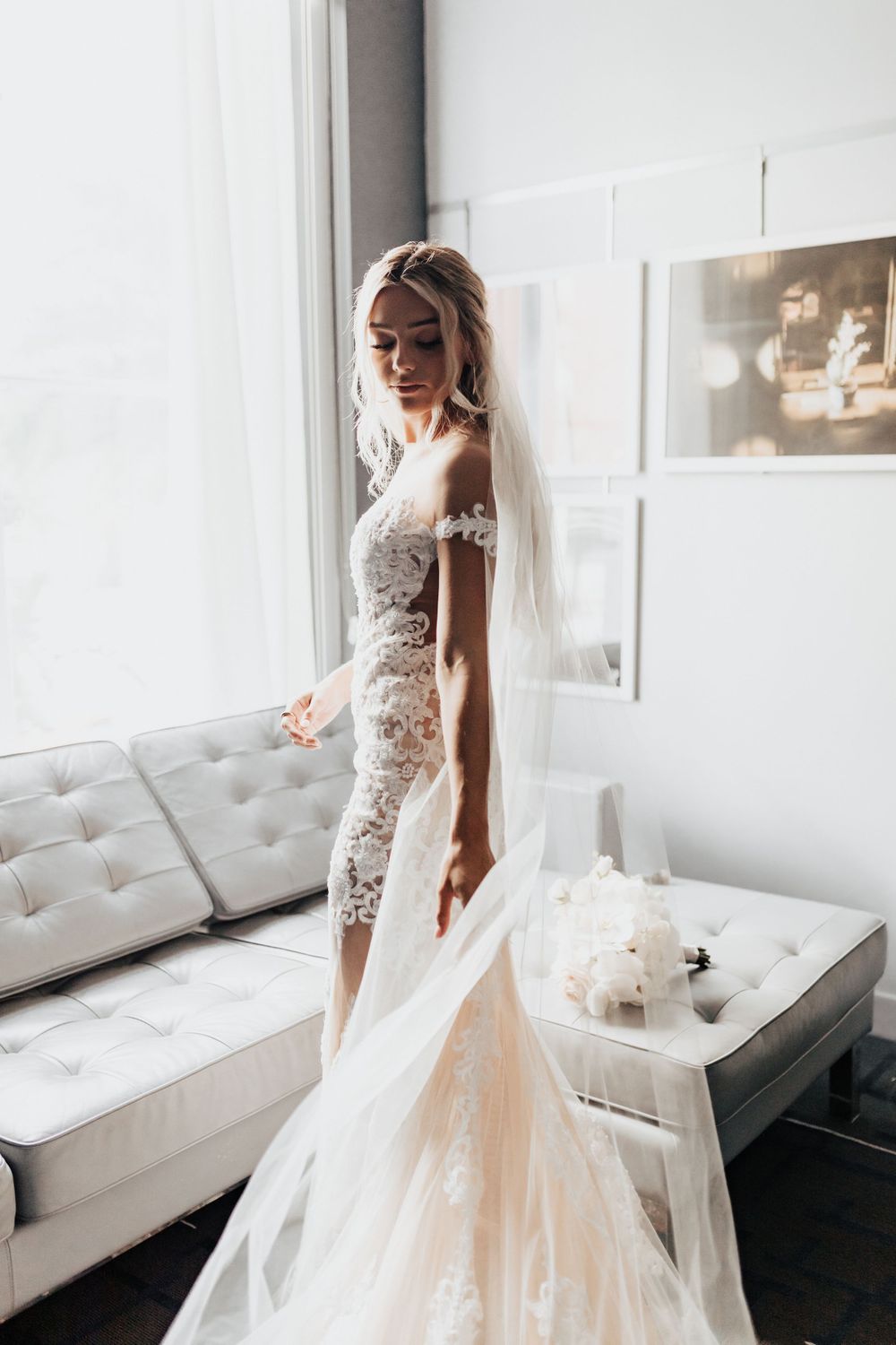 A romantic bridal portrait showing delicate lace details and flowing veil in soft window light.