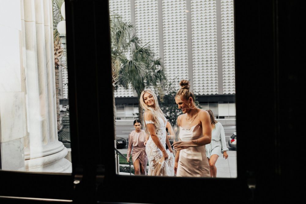 Joyful celebration seen through a window frame with architectural columns visible.