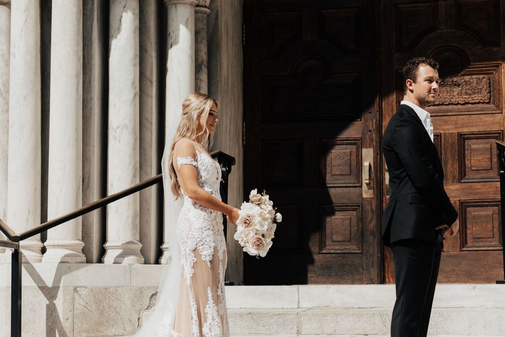 An elegant wedding moment captured on ornate stone steps with classic architecture.