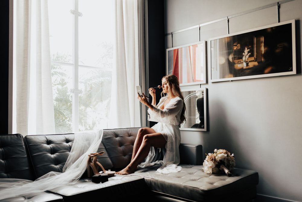 Soft morning light streams through window onto grey couch in modern room with framed artwork.
