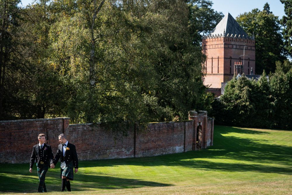 two grooms walk the perimeter of the walled garden at the elvetham