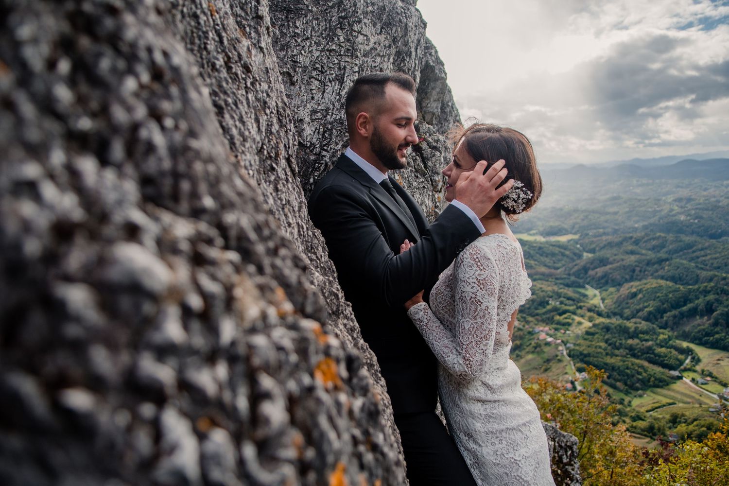A tender moment shared against a rocky mountain backdrop with valley views.