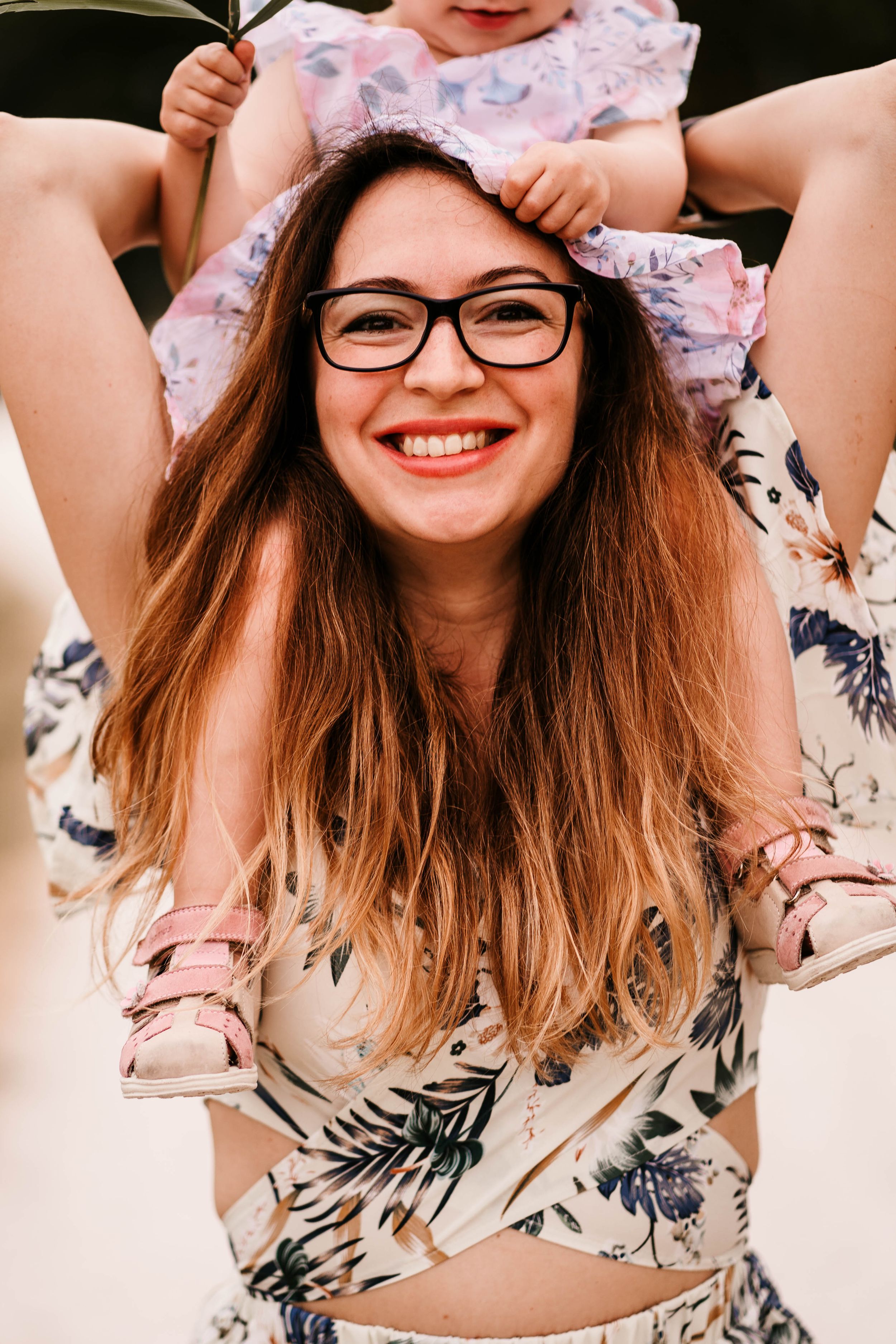 A joyful summer portrait captured during a playful piggyback moment outdoors.